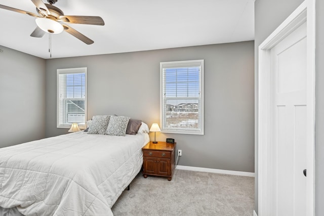 bedroom with light carpet, a ceiling fan, and baseboards