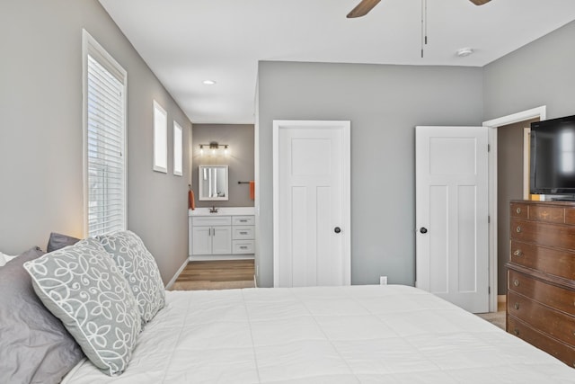 bedroom with recessed lighting, a sink, a ceiling fan, baseboards, and ensuite bath