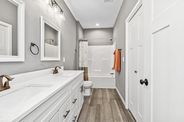 full bathroom with a sink, shower / bathtub combination with curtain, toilet, and wood finished floors