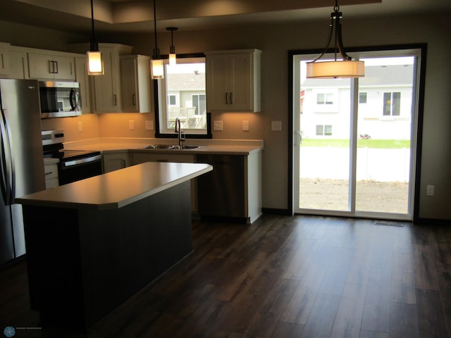 kitchen with a center island, stainless steel appliances, a wealth of natural light, and sink