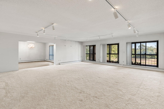 empty room with light carpet, a textured ceiling, and a baseboard heating unit