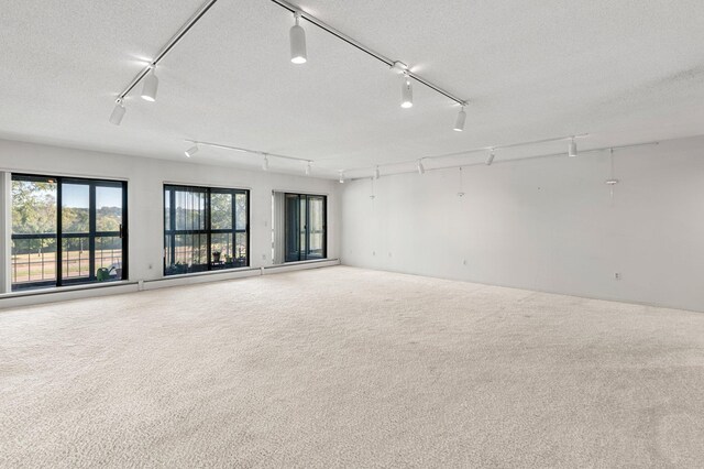 carpeted spare room featuring a textured ceiling