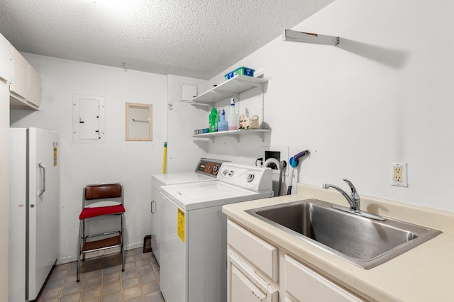 washroom with washing machine and clothes dryer, sink, cabinets, electric panel, and a textured ceiling