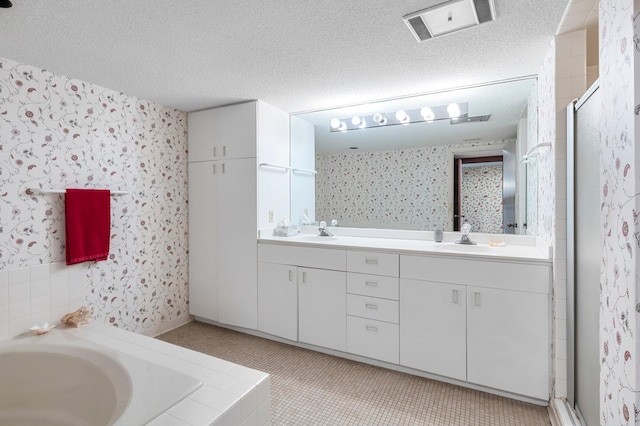 bathroom featuring vanity, a textured ceiling, and separate shower and tub