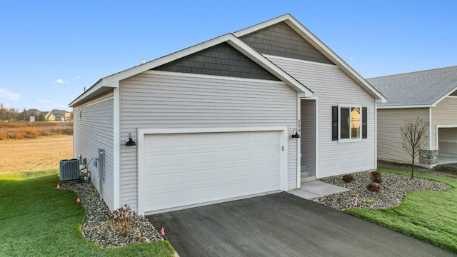 view of front of home featuring central AC unit, a front lawn, and a garage