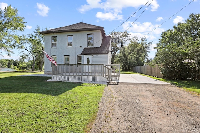 view of front of home with a wooden deck and a front lawn