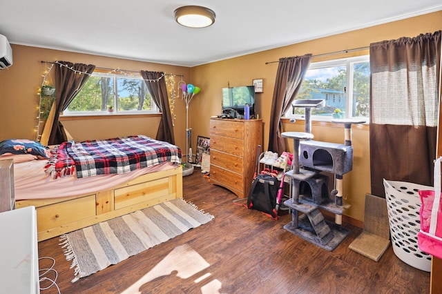 bedroom with a wall unit AC, multiple windows, and dark wood-type flooring