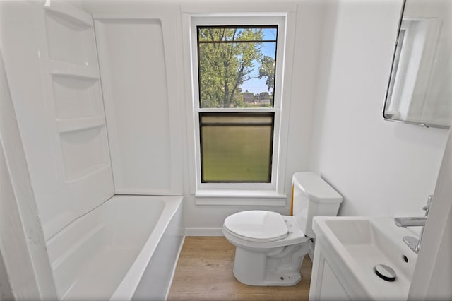 full bathroom featuring sink, toilet, washtub / shower combination, and hardwood / wood-style flooring