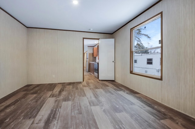 unfurnished room with crown molding and light hardwood / wood-style floors