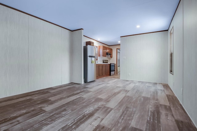 unfurnished living room with ornamental molding and light wood-type flooring