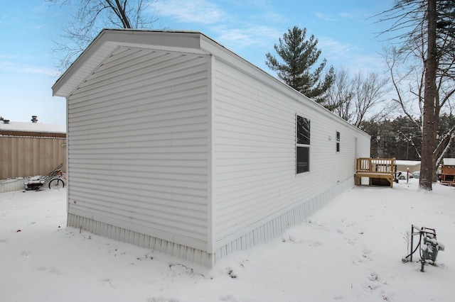 view of snowy exterior with a wooden deck