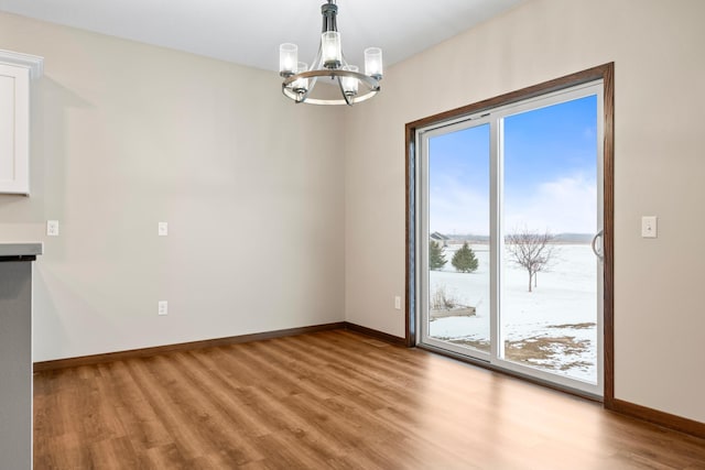 unfurnished dining area featuring light hardwood / wood-style flooring and a chandelier