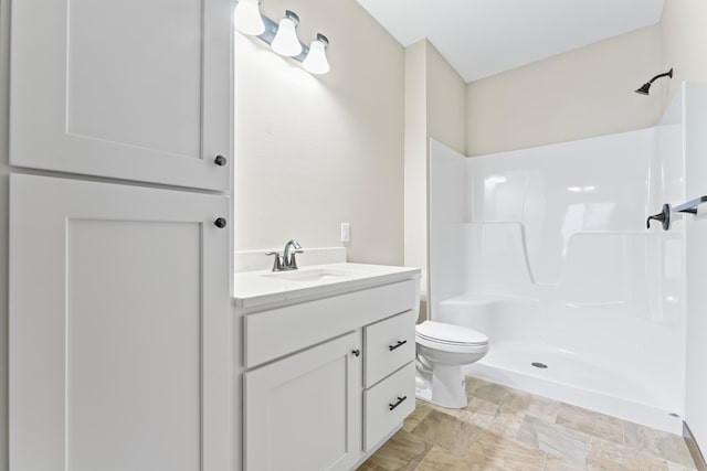 bathroom with vanity, toilet, and a shower