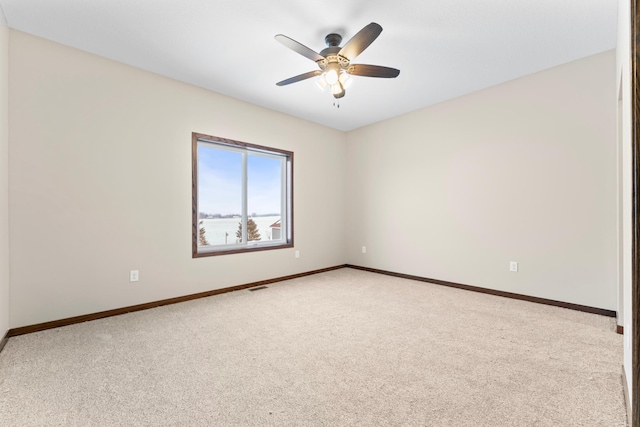 carpeted spare room with ceiling fan