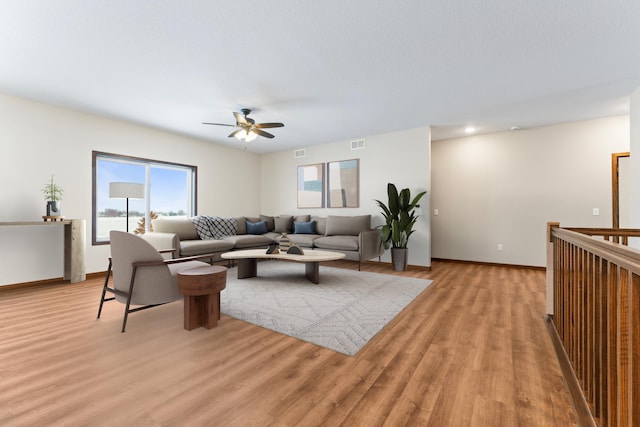 living room featuring ceiling fan and light hardwood / wood-style flooring