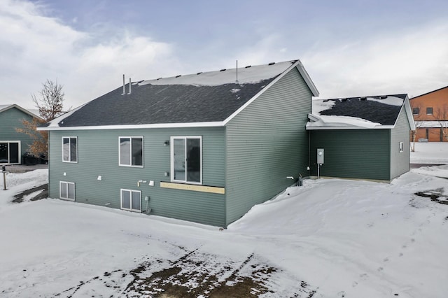 view of snow covered back of property