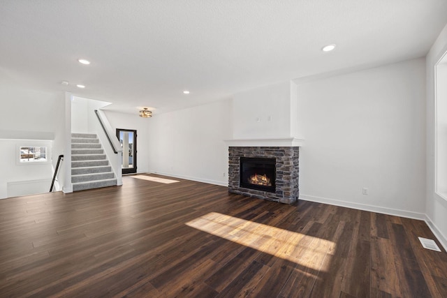 unfurnished living room with dark wood-type flooring and a fireplace