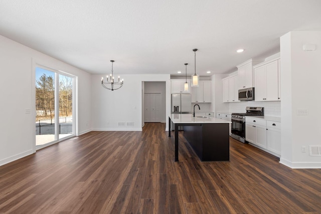 kitchen featuring stainless steel appliances, decorative backsplash, hanging light fixtures, and sink