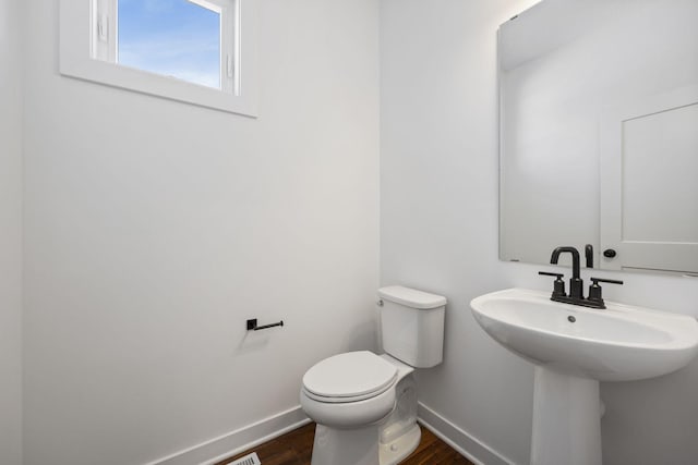 bathroom featuring toilet, hardwood / wood-style flooring, and sink