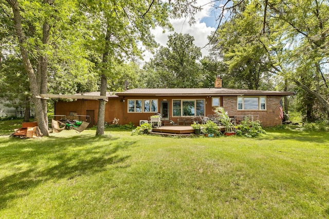 back of house featuring a lawn and a deck