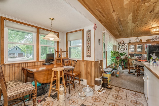 carpeted dining area featuring a textured ceiling, wooden walls, a baseboard heating unit, and wood ceiling