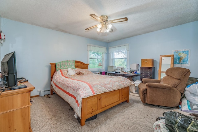 carpeted bedroom featuring ceiling fan, a textured ceiling, and a baseboard heating unit