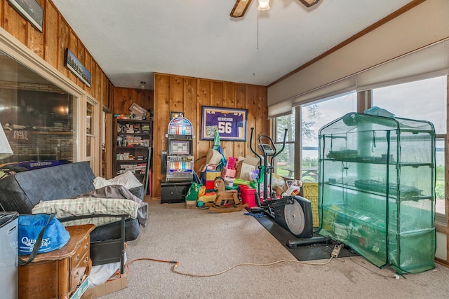 interior space featuring ceiling fan, carpet floors, and wooden walls