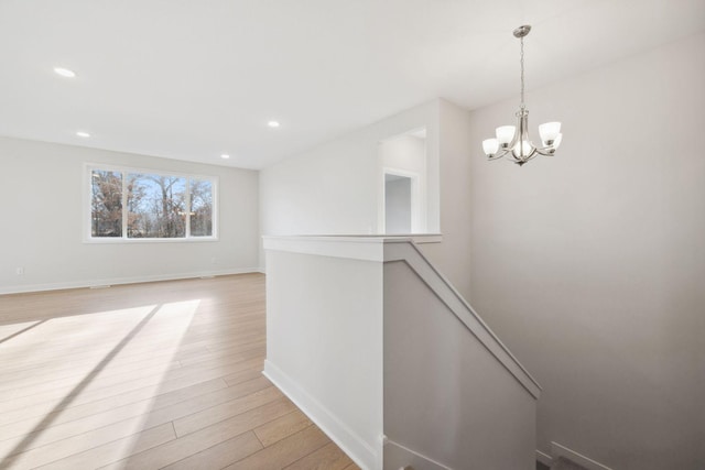 hall featuring light hardwood / wood-style floors and a notable chandelier