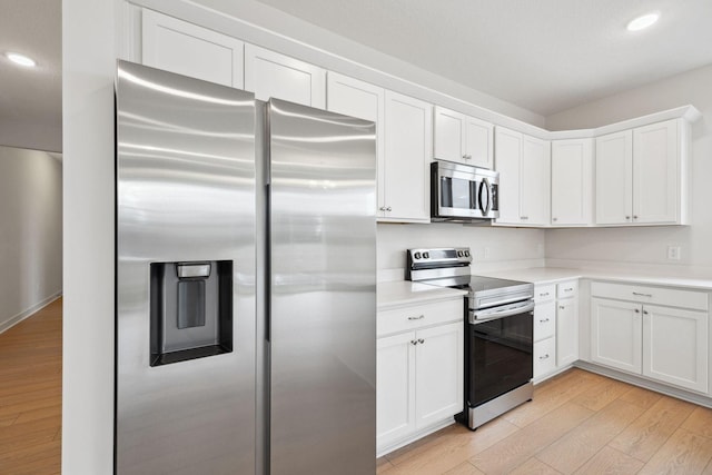 kitchen featuring white cabinets, stainless steel appliances, and light hardwood / wood-style floors