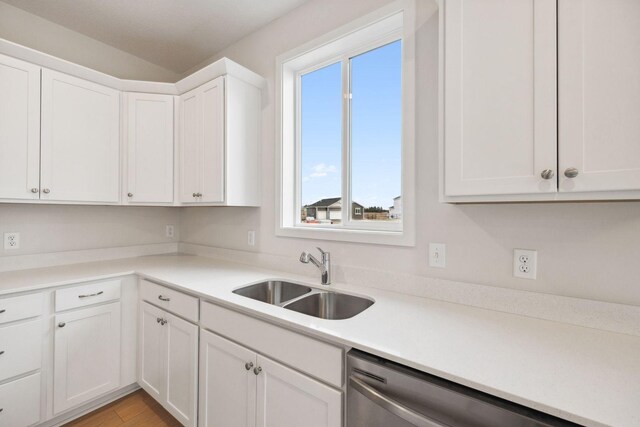 kitchen with dishwasher, sink, white cabinets, and light hardwood / wood-style floors