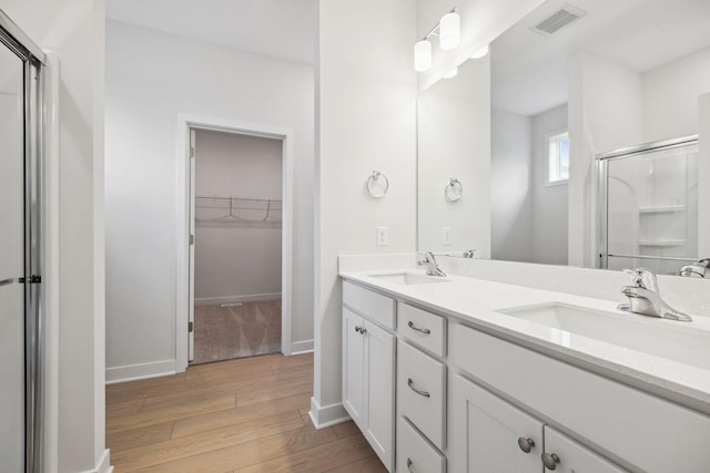 bathroom with hardwood / wood-style floors, vanity, and walk in shower