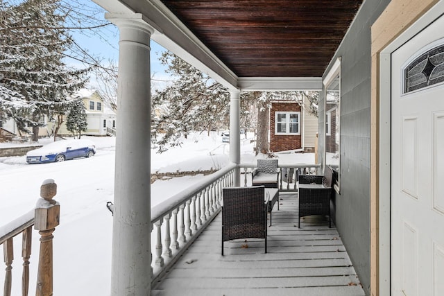 snow covered deck with covered porch