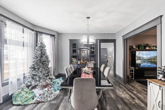 dining space with dark hardwood / wood-style floors, a textured ceiling, and an inviting chandelier