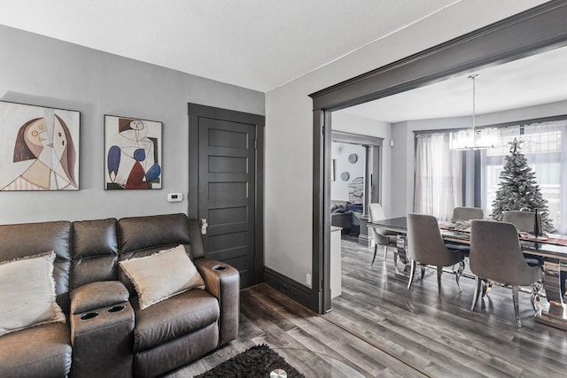 living room featuring a textured ceiling, an inviting chandelier, and dark wood-type flooring