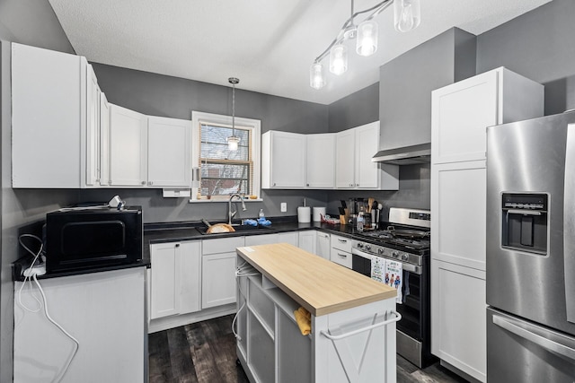 kitchen featuring pendant lighting, dark wood-type flooring, white cabinets, sink, and stainless steel appliances