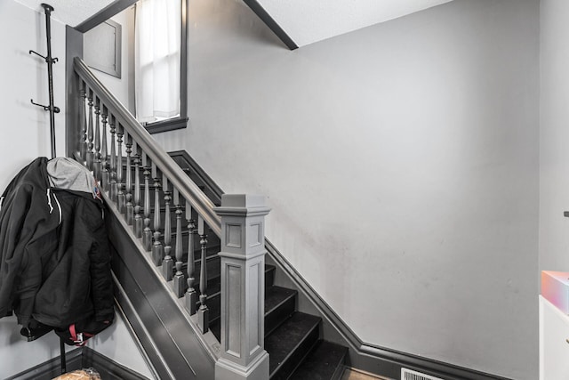 stairs with a textured ceiling