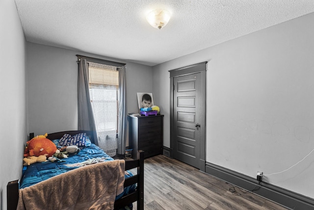 bedroom with wood-type flooring and a textured ceiling