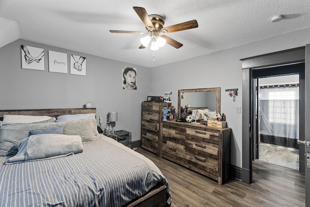 bedroom with hardwood / wood-style floors, ceiling fan, lofted ceiling, and a textured ceiling