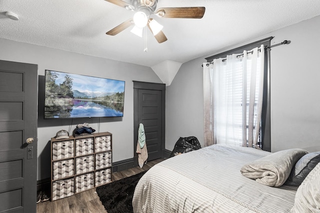 bedroom featuring a textured ceiling, dark hardwood / wood-style flooring, ceiling fan, and lofted ceiling