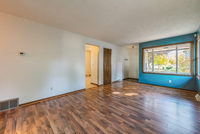 empty room featuring dark wood-type flooring