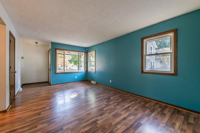 spare room with dark hardwood / wood-style floors