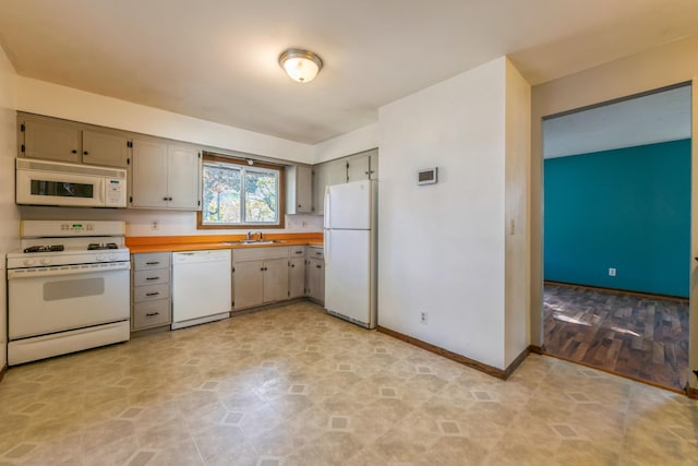 kitchen featuring white appliances, gray cabinets, and sink