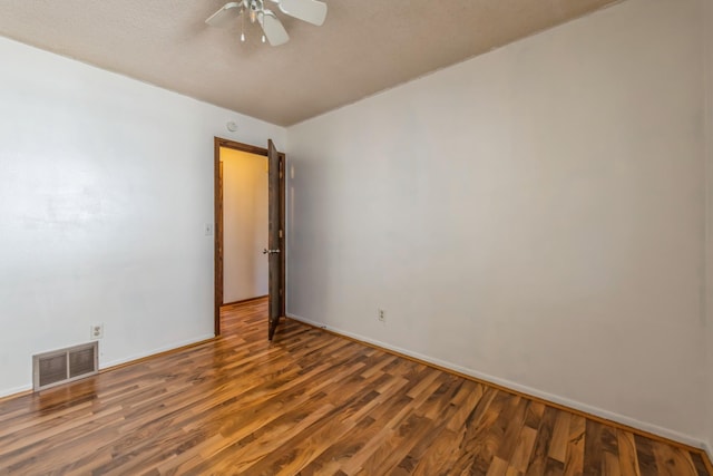 empty room with dark hardwood / wood-style floors and ceiling fan