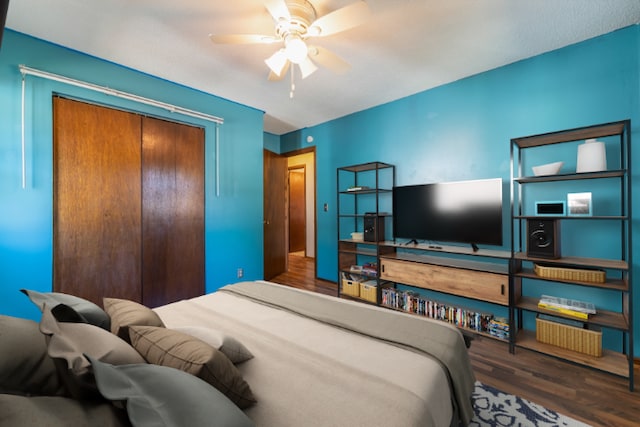 bedroom featuring ceiling fan, dark wood-type flooring, and a closet