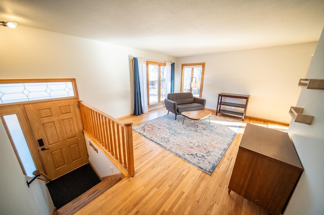 living area featuring stairway and wood finished floors