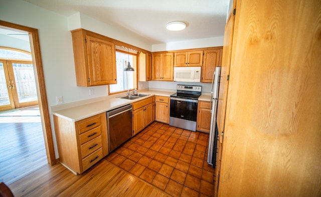 kitchen featuring dark wood finished floors, appliances with stainless steel finishes, light countertops, and a sink