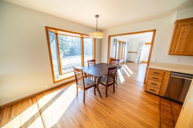 dining area featuring baseboards and light wood finished floors