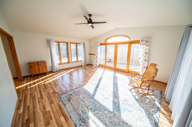 unfurnished room with wood finished floors, a ceiling fan, baseboards, vaulted ceiling, and french doors