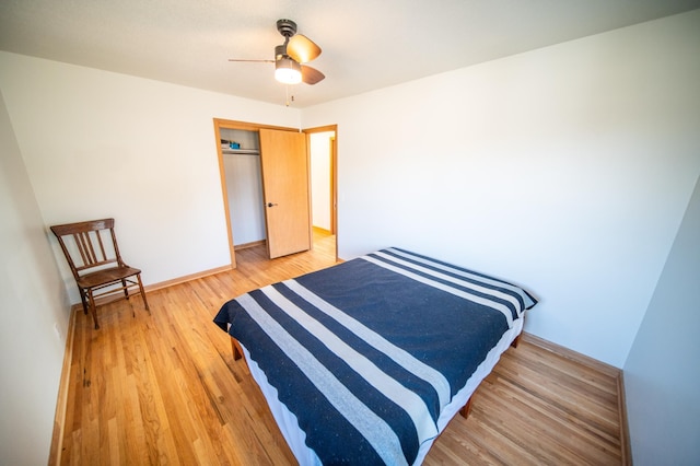 bedroom with a ceiling fan, baseboards, a closet, and light wood finished floors