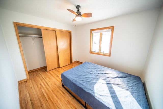 bedroom featuring a closet, light wood-style flooring, baseboards, and ceiling fan